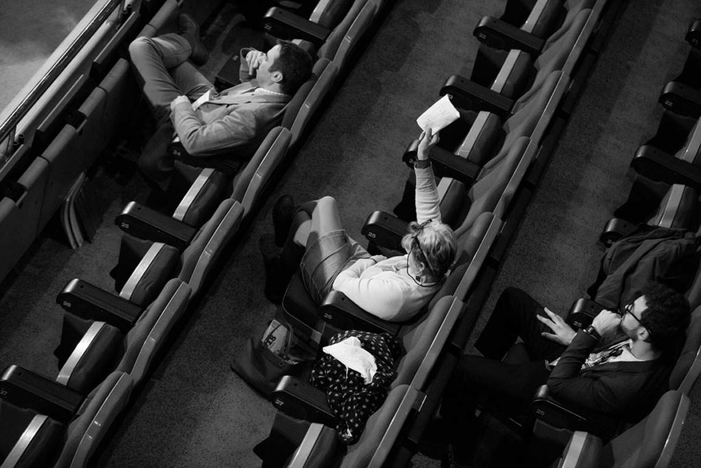 Lady holding her hand up to ask a question at an event