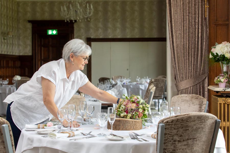 Lady setting the wedding flowers on the table