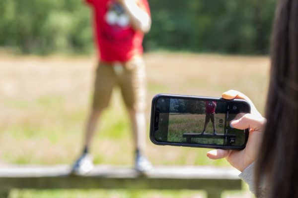 A bad photo of someone taking a photo on a phone.